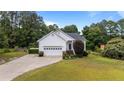 Charming single-Gathering home featuring a two-car garage, brick accents, and mature landscaping in a quiet neighborhood at 6301 Mockingbird Ln, Sanford, NC 27332