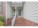 Inviting covered front porch with brick stairs and white railing, offering a welcoming entrance at 177 Lamplighter Way, Spring Lake, NC 28390