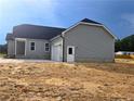 View of the home's side elevation, featuring light gray siding, attached garage, and well-maintained lawn at 24 Roll Tide Ct, Angier, NC 27501