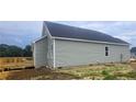 Side view of a new construction home with a wooden deck, set on a spacious lot at 24 Roll Tide Ct, Angier, NC 27501