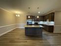 Open kitchen with granite countertops, kitchen island, stainless appliances, and modern light fixtures at 240 Gallery Dr # 301, Spring Lake, NC 28390
