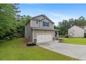 Well-maintained home featuring a two-car garage, manicured lawn, and lovely curb appeal at 265 Tactical Dr, Bunnlevel, NC 28323