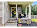 Inviting front porch featuring decorative sunflowers on the door and a cozy bench at 265 Tactical Dr, Bunnlevel, NC 28323