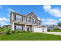 Beautiful two-story house featuring a three-car garage and lush green lawn at 90 Stock Market Dr, Broadway, NC 27505