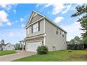 Exterior view of a two-story home showcasing the side yard and a two-car garage at 94 Heatherwood Dr, Lillington, NC 27546