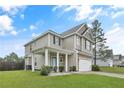 Two-story home with neutral siding, a covered front porch and an attached two-car garage at 94 Heatherwood Dr, Lillington, NC 27546