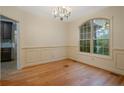 Bright dining room featuring hardwood floors, wainscoting, and a large arched window at 98 Pineridge Cv, Sanford, NC 27332