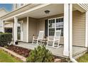 Inviting covered front porch features rocking chairs, plants, and a neatly landscaped garden bed at 12 Schoomaker Ct, Broadway, NC 27505