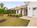 Welcoming entrance with a covered porch, decorative blue door and well manicured landscaping at 25 Vast View Way, Youngsville, NC 27596