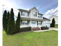 Lovely two-story home featuring a cozy front porch, mature trees and a well-maintained lawn at 554 Lenoir Dr, Spring Lake, NC 28390