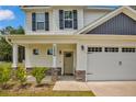 Inviting home with a two-car garage, covered porch, and stone accents enhancing its curb appeal at 1224 Micro Tower Rd, Lillington, NC 27546