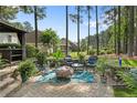 Picturesque backyard featuring a patio, fire pit, outdoor seating, and mature trees for privacy at 256 Barons W Run, Spring Lake, NC 28390