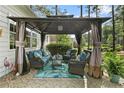 Relaxing outdoor patio with seating area, pergola, and lush landscaping, perfect for entertaining guests at 256 Barons W Run, Spring Lake, NC 28390