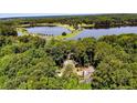 Panoramic aerial view displaying the home nestled amidst lush greenery near a picturesque lake and surrounding forest at 397 Back Bay, Sanford, NC 27332