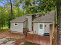 Cozy home exterior featuring a private patio, a fenced privacy area, and beautiful mature trees at 968 S Bay Dr, Sanford, NC 27332
