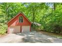 Exterior shot of detached two-car garage surrounded by lush trees in a sunny setting at 1116 Falling Strm, Sanford, NC 27332
