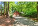 View of detached two-car garage and long drive, surrounded by mature trees and green foliage at 1116 Falling Strm, Sanford, NC 27332