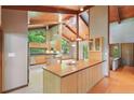 Bright kitchen with wood cabinets, striking wood beam ceiling, and an island with seating at 1116 Falling Strm, Sanford, NC 27332
