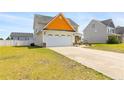 Side view of a two-story home with a two-car garage and well-maintained lawn at 152 Century Dr, Cameron, NC 28326
