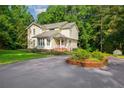 Two-story home with yellow siding and mature landscaping, surrounded by lush green trees at 1718 Carthage St, Sanford, NC 27330