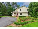Two-story home with yellow siding, brick steps, and mature landscaping at 1718 Carthage St, Sanford, NC 27330