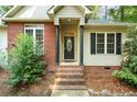 Close-up of the front entrance with brick stairs and black door with oval window at 3245 Bristol St, Sanford, NC 27332