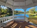 Inside a lovely white gazebo looking out on a tranquil pond, featuring bench seating and serene water views at 3647 Olivia Rd, Sanford, NC 27332