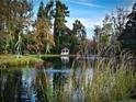 Beautiful tranquil pond with a fountain, featuring a gazebo nestled among the trees, creating a peaceful setting at 3647 Olivia Rd, Sanford, NC 27332