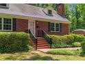 Close-up of front porch with brick steps, black railing and manicured hedges at 511 Maplewood Dr, Sanford, NC 27330