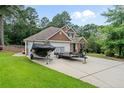 Charming two-story home with manicured lawn, two-car garage, and boat parked in the driveway at 69 Night Heron Ct, Sanford, NC 27332