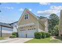 Side view of a two-car garage with white doors, a pergola, and trimmed bushes at 716 Micahs N Way, Spring Lake, NC 28390