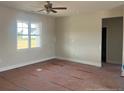 Unfinished living room showcasing a ceiling fan, a window, and an open doorway at 1036 Turlington Rd, Dunn, NC 28334