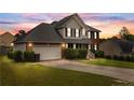 Beautiful two-story home with brick and siding, an attached two-car garage, and lush green lawn at dusk at 225 Woodshire Dr, Lillington, NC 27546