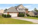 Inviting two-story home with brick and siding, a green lawn, and a convenient attached two-car garage at 225 Woodshire Dr, Lillington, NC 27546
