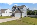 Two-story home showcasing a well-manicured lawn, stone accents, and a two-car garage at 334 Bunting Dr, Lillington, NC 27546