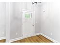 Clean and well-lit entryway with wood-look flooring, white door with window, and fresh paint at 7057 Oak Rd, Sanford, NC 27332