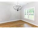 Bright living area featuring a modern chandelier, hardwood floors, and a large window at 7057 Oak Rd, Sanford, NC 27332