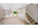 Cozy living room featuring neutral carpet, light gray walls, and staircase at 1255 Donaldson Ct, Cary, NC 27511