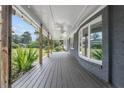 Inviting covered porch with a gray brick wall, wooden floors, ceiling fans, and a view of the manicured lawn at 177 Gladiola Dr, Spring Lake, NC 28390