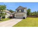 Inviting two-story home with a two-car garage, lush lawn, and a charming front yard in a Gathering-friendly neighborhood at 18 Hallow Oak St, Spring Lake, NC 28390