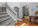 Elegant foyer with hardwood floors, stairs, and an archway leading to a warmly lit room at 364 Heathrow Dr, Spring Lake, NC 28390