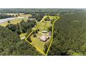 Expansive aerial view of a property, surrounded by lush greenery and marked with a yellow property outline at 472 Walter Bright Rd, Sanford, NC 27330