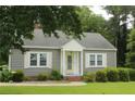 Gray siding, white trim, yellow door and a well-manicured lawn add to the curb appeal of this charming single-story home at 4903 Lemon Springs Rd, Sanford, NC 27332