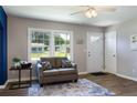 Bright living room features neutral walls, wood floors, and a comfortable gray loveseat at 108 Pine St, Dunn, NC 28334