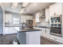 Modern kitchen with white cabinets, stainless steel appliances, and a stylish island with stone countertop at 193 Jim S Rd, Cameron, NC 28326