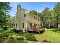Rear exterior with a wooden deck, patio seating, and a spacious, well-maintained lawn at 609 Fairway Dr, Sanford, NC 27330