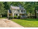 Traditional home with a lush green lawn, driveway, mature landscaping, and a welcoming front porch at 609 Fairway Dr, Sanford, NC 27330