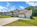 Lovely two-story home with a manicured lawn, three-car garage, stone accents, and a concrete driveway at 66 S Hawks Ridge Ln, Smithfield, NC 27577