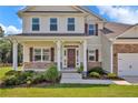 Inviting two-story home with stone accents, manicured lawn, covered porch, and elegant front entrance at 66 S Hawks Ridge Ln, Smithfield, NC 27577