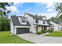 Charming two-story home features a manicured lawn, covered porch with wood posts, and a convenient attached garage at 182 Navaho Trl, Sanford, NC 27332